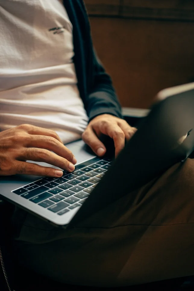Hands typing on a laptop keyboard
