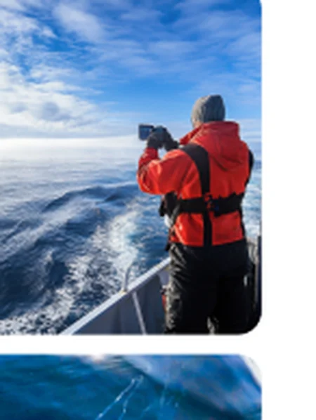 Person in red jacket looking out from a vessel
