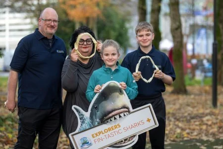 Explorers pupils and adults holding a shark display sign