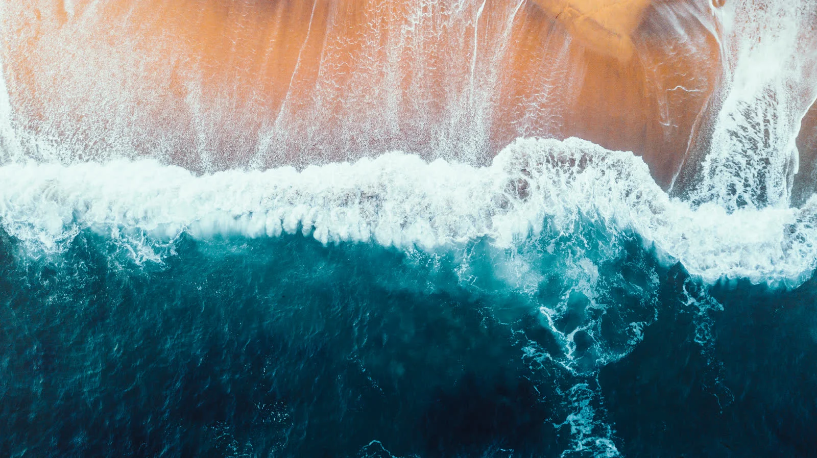 Aerial view of waves breaking along the shore