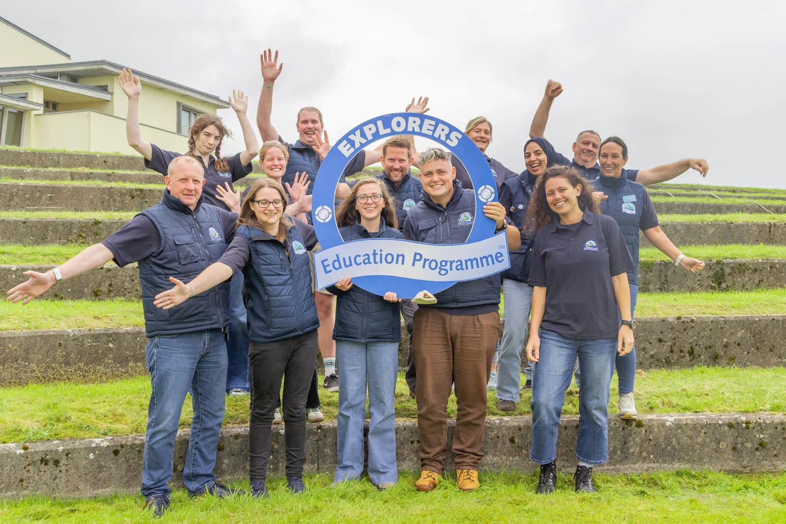 Explorers Education Programme team holding a blue programme sign