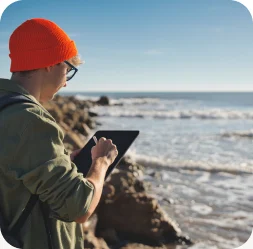 Coastal researcher entering observations on a tablet