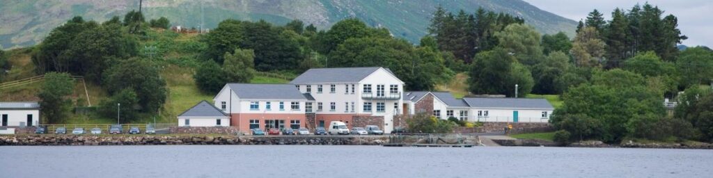 Newport research buildings on a lakeshore with wooded hills and mountains behind.