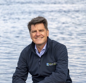 Marine Institute CEO seated outdoors beside the sea
